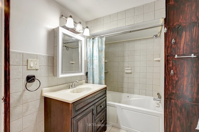 bathroom with tile walls, vanity, and shower / tub combo