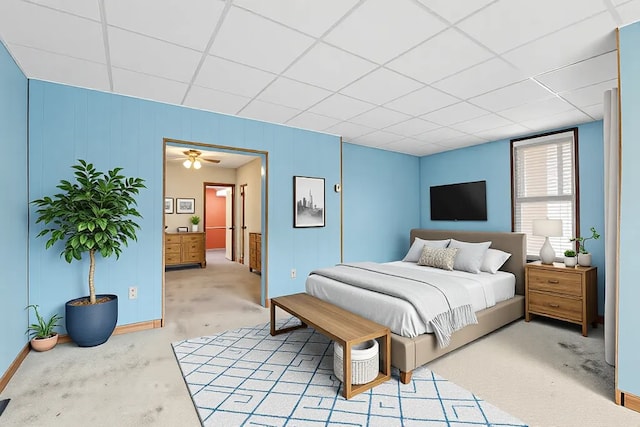 bedroom featuring a drop ceiling and light carpet