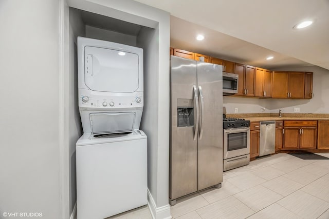 4337 S Prairie Ave Unit G, Chicago, IL 60653 - kitchen with light countertops, brown cabinets, stainless steel appliances, recessed lighting, and stacked washer and dryer