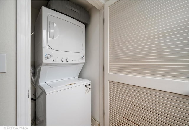 clothes washing area with stacked washer / dryer and laundry area