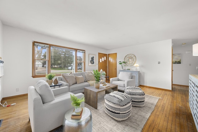 living area featuring baseboards and hardwood / wood-style flooring