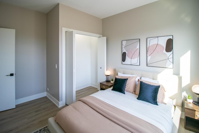 bedroom with baseboards and wood finished floors