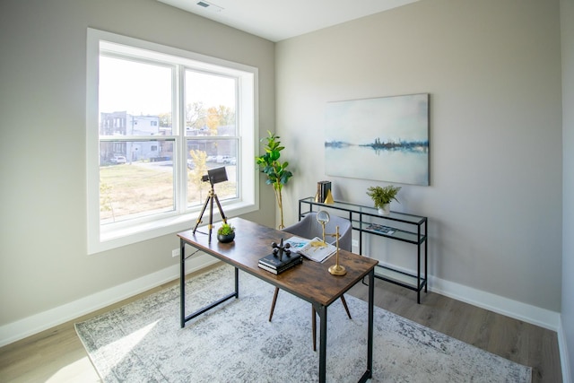 office space with wood finished floors, baseboards, and plenty of natural light