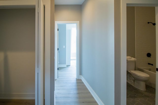 hall featuring baseboards and wood finished floors