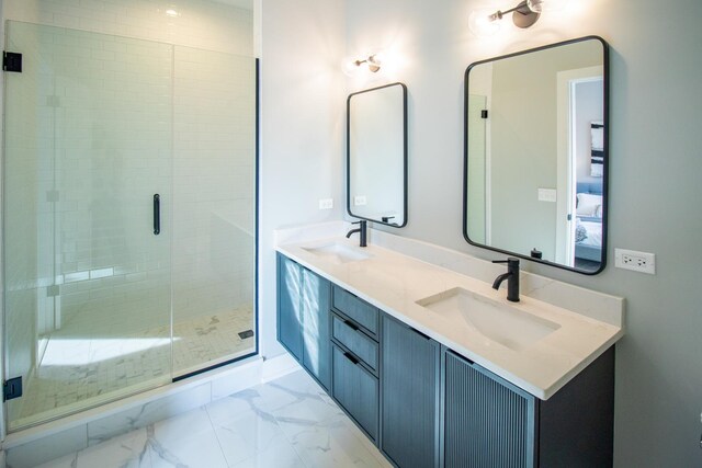 bathroom with double vanity, marble finish floor, a sink, and a stall shower