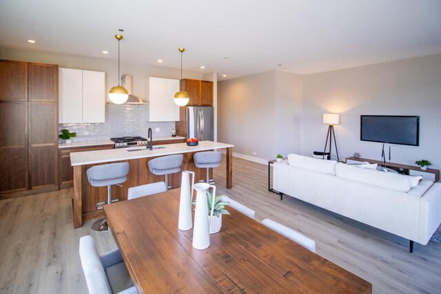 dining area with light wood-style flooring, baseboards, and recessed lighting