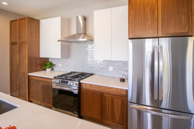kitchen with tasteful backsplash, brown cabinetry, wall chimney exhaust hood, and stainless steel appliances