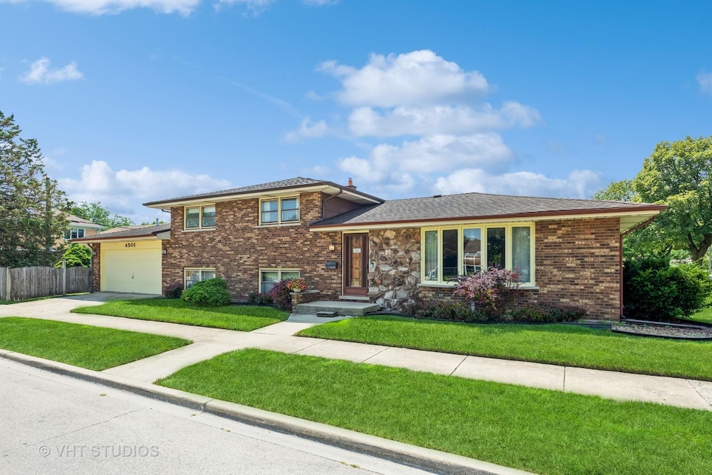 4501 Raymond Ave, Brookfield, IL 60513 - tri-level home featuring fence, an attached garage, driveway, brick siding, and a front yard