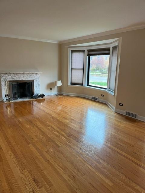 1911 N 73rd Ave N, Elmwood Park, IL 60707 - unfurnished living room featuring ornamental molding, wood finished floors, and a fireplace