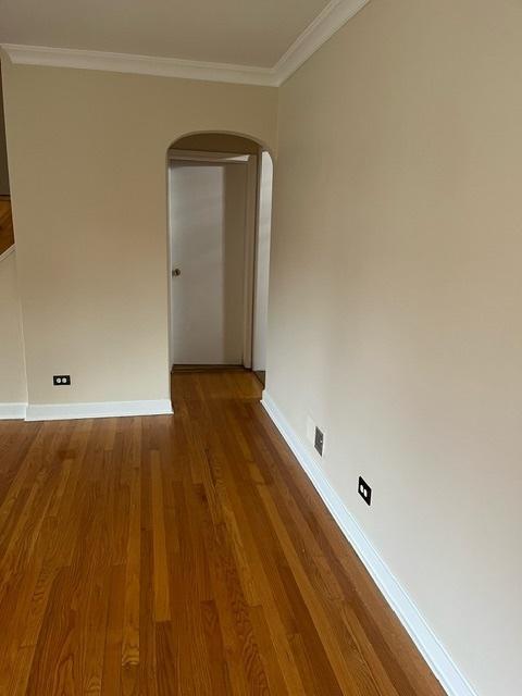 1911 N 73rd Ave N, Elmwood Park, IL 60707 - unfurnished room featuring arched walkways, wood finished floors, and crown molding