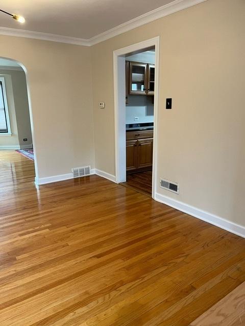 1911 N 73rd Ave N, Elmwood Park, IL 60707 - unfurnished room with arched walkways, ornamental molding, and light wood-style flooring