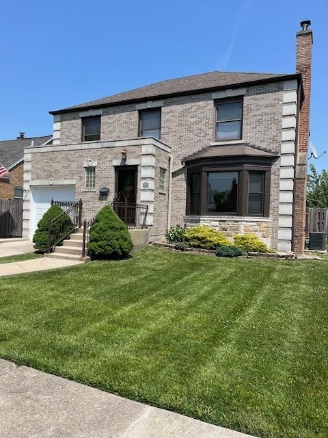 1911 N 73rd Ave N, Elmwood Park, IL 60707 - view of front of house with a chimney, a garage, stone siding, and brick siding