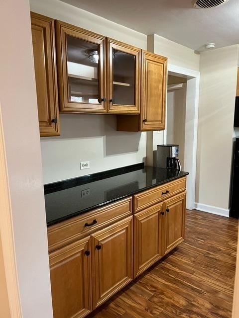 1911 N 73rd Ave N, Elmwood Park, IL 60707 - kitchen featuring dark wood-style flooring, brown cabinets, and glass insert cabinets
