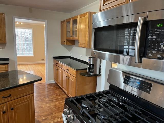 1911 N 73rd Ave N, Elmwood Park, IL 60707 - kitchen featuring stainless steel appliances, wood finished floors, glass insert cabinets, and brown cabinets