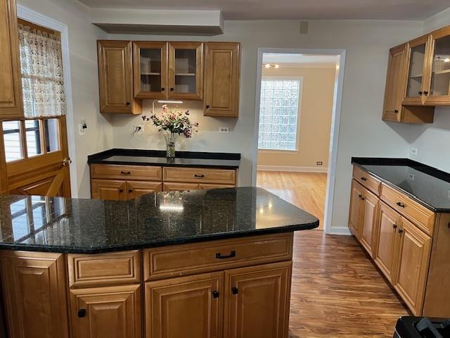 1911 N 73rd Ave N, Elmwood Park, IL 60707 - kitchen with wood finished floors, glass insert cabinets, dark stone counters, and brown cabinets