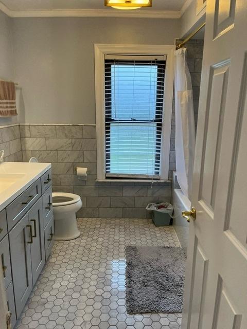 1911 N 73rd Ave N, Elmwood Park, IL 60707 - bathroom with tile walls, vanity, ornamental molding, shower / bathtub combination with curtain, and tile patterned flooring