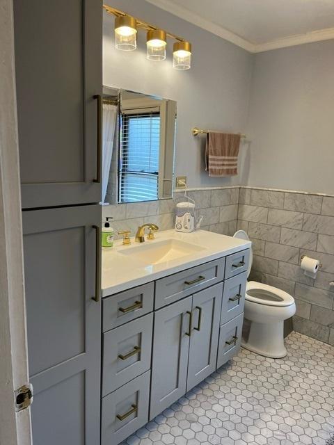 1911 N 73rd Ave N, Elmwood Park, IL 60707 - full bath featuring tile patterned flooring, tile walls, vanity, ornamental molding, and a wainscoted wall