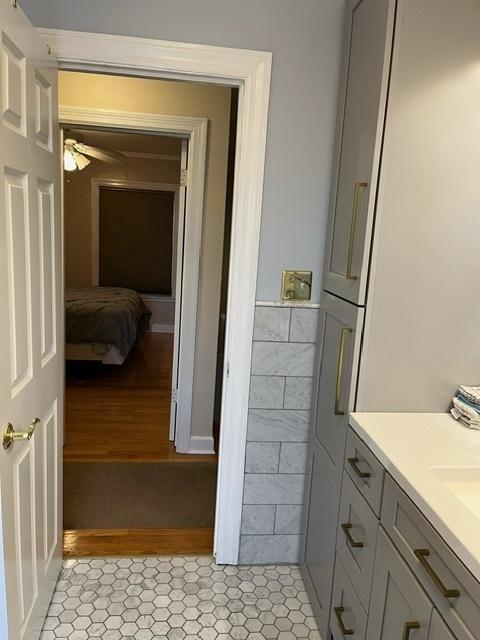 1911 N 73rd Ave N, Elmwood Park, IL 60707 - bathroom featuring wood finished floors, vanity, wainscoting, and tile walls