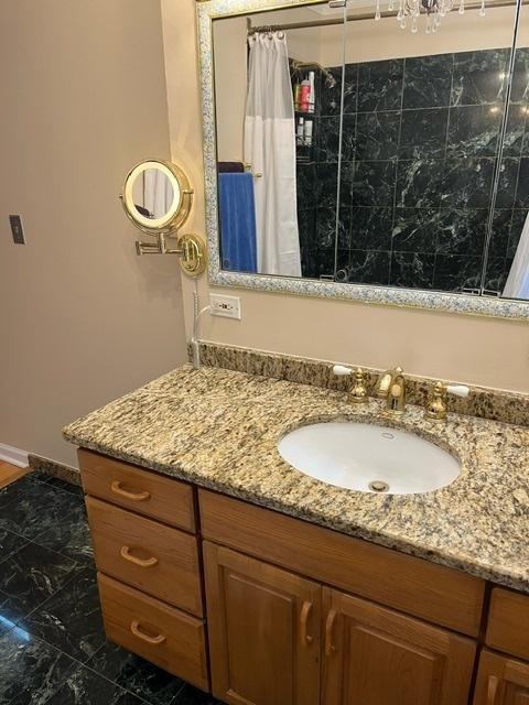1911 N 73rd Ave N, Elmwood Park, IL 60707 - bathroom with vanity, a tile shower, and marble finish flooring