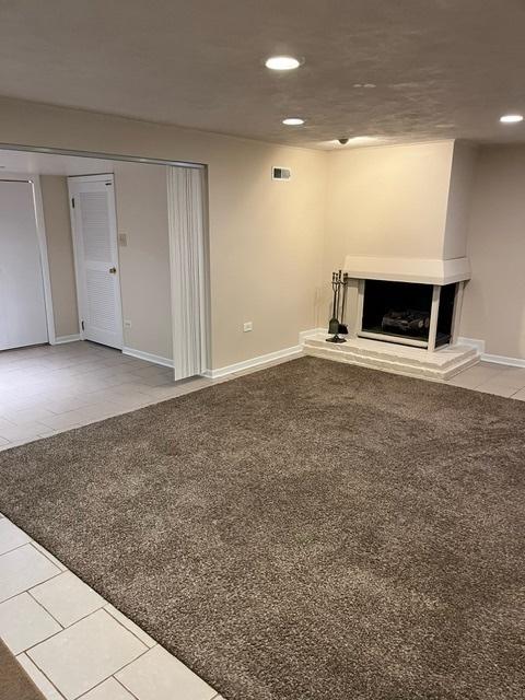 1911 N 73rd Ave N, Elmwood Park, IL 60707 - unfurnished living room with recessed lighting, a fireplace with raised hearth, and tile patterned flooring