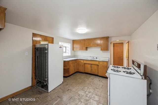 3101 S 53rd Ct, Cicero, IL 60804 - kitchen featuring brown cabinetry, gas range gas stove, fridge, light countertops, and a sink