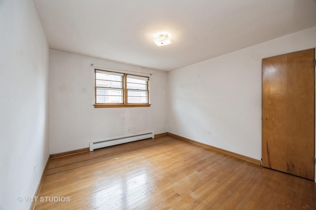3101 S 53rd Ct, Cicero, IL 60804 - spare room featuring baseboards, light wood-type flooring, and a baseboard radiator