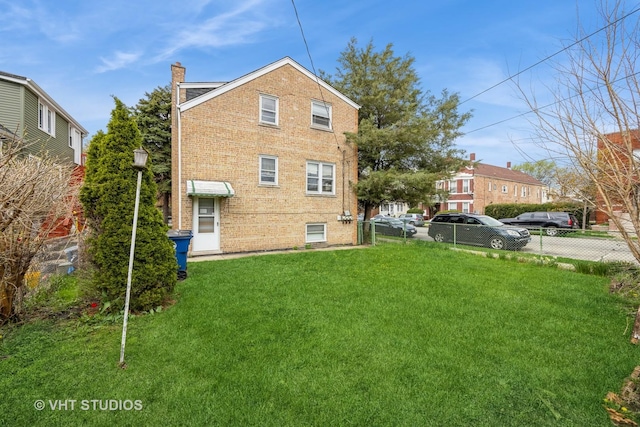 3101 S 53rd Ct, Cicero, IL 60804 - rear view of house with brick siding, fence, a yard, and a chimney