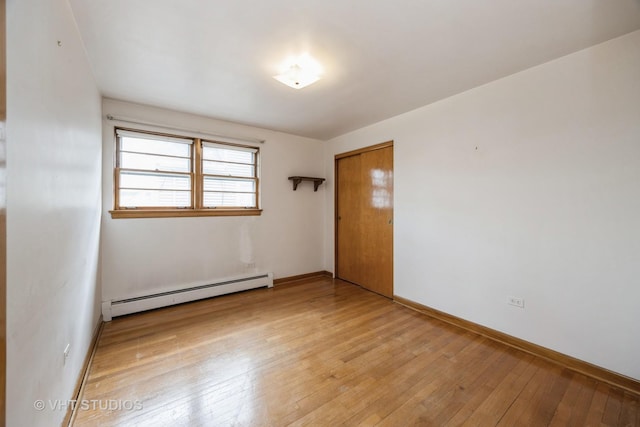 3101 S 53rd Ct, Cicero, IL 60804 - empty room featuring baseboards, a baseboard heating unit, and light wood-type flooring