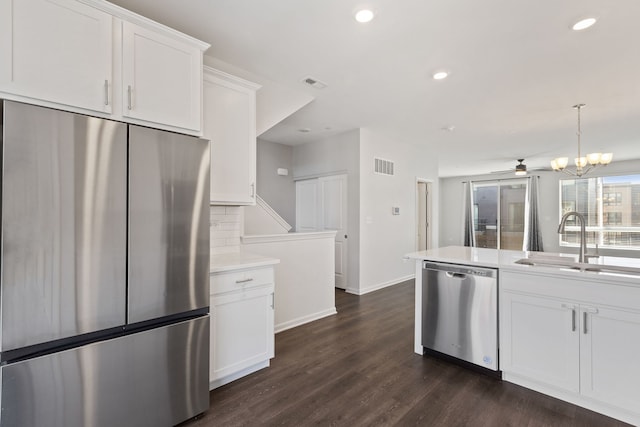 kitchen featuring stainless steel appliances, visible vents, white cabinetry, and a sink