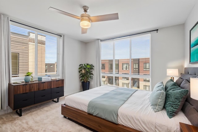 bedroom featuring light colored carpet and a ceiling fan