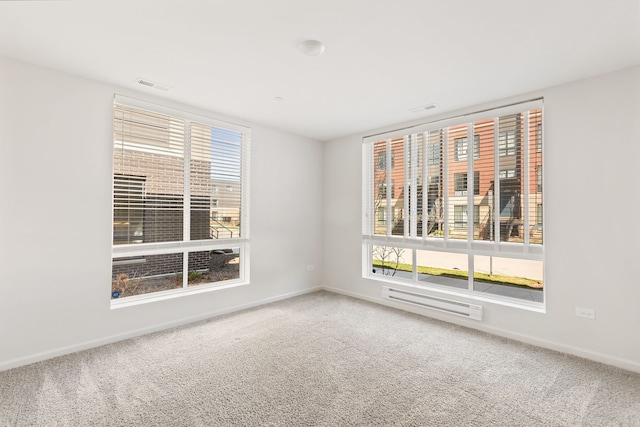 carpeted spare room featuring visible vents and baseboards