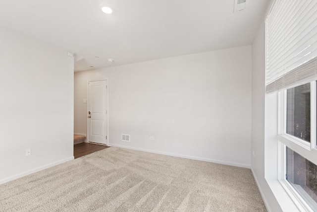 unfurnished room with visible vents, baseboards, and carpet