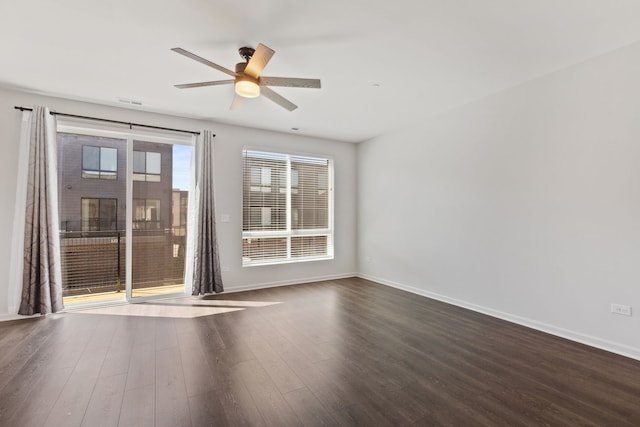 spare room with ceiling fan, baseboards, and dark wood-style floors