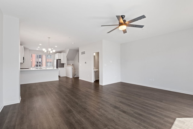unfurnished living room with visible vents, baseboards, dark wood finished floors, recessed lighting, and ceiling fan with notable chandelier