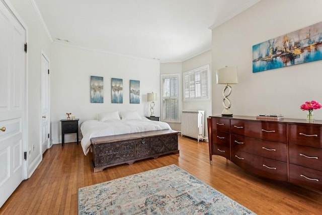 bedroom featuring radiator, crown molding, and wood finished floors