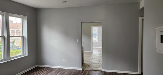 unfurnished room with dark wood-style floors and baseboards