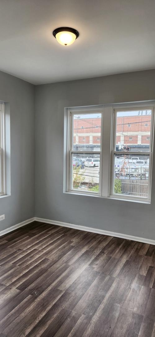 spare room with dark wood finished floors and baseboards