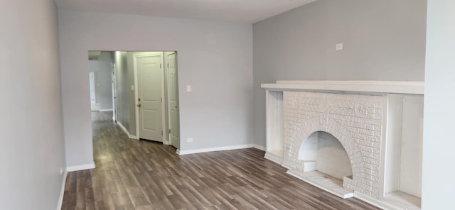 unfurnished living room featuring baseboards, a fireplace, and wood finished floors