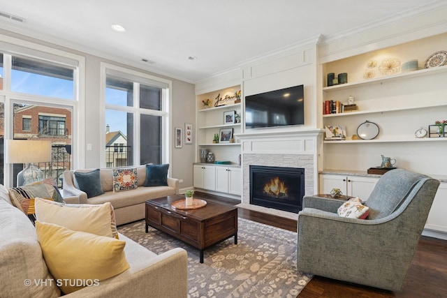 4845 N Damen Ave Unit 3S, Chicago, IL 60625 - living room featuring a fireplace, ornamental molding, visible vents, dark wood-style flooring, and built in shelves
