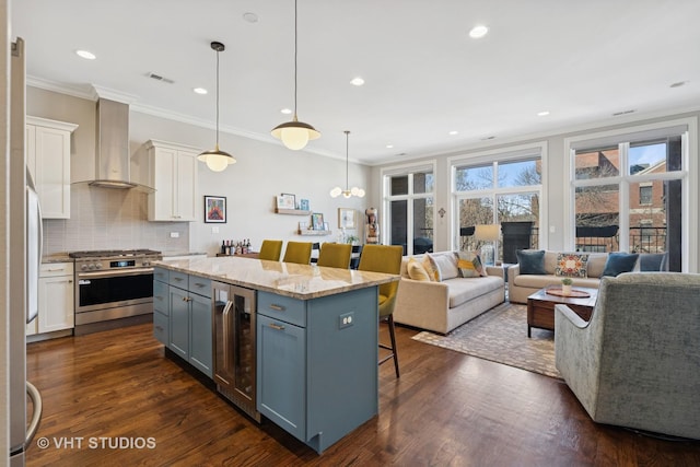 4845 N Damen Ave Unit 3S, Chicago, IL 60625 - kitchen featuring visible vents, stainless steel range with gas stovetop, wall chimney range hood, a kitchen bar, and wine cooler