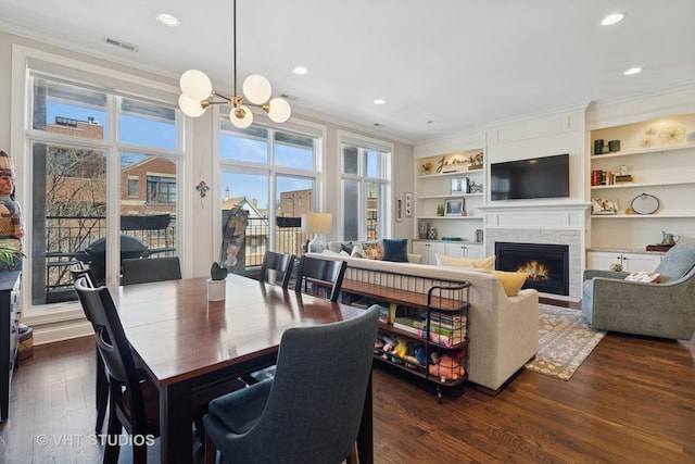 4845 N Damen Ave Unit 3S, Chicago, IL 60625 - dining space with visible vents, built in features, ornamental molding, a lit fireplace, and dark wood-type flooring