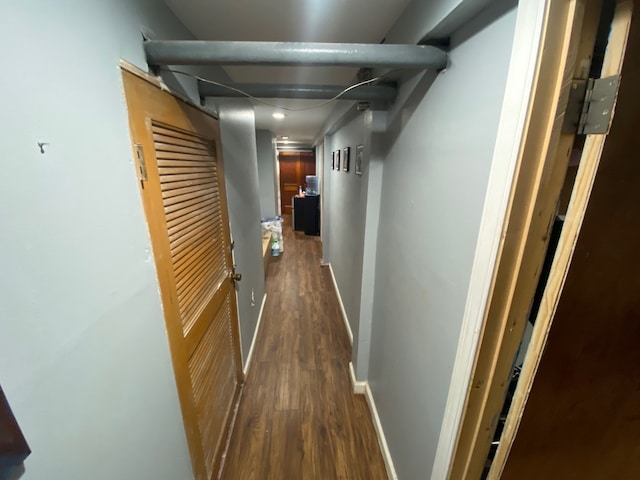 corridor featuring baseboards and dark wood finished floors