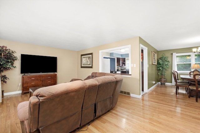 910 Sarah Ln, Aurora, IL 60502 - living room featuring light wood finished floors, baseboards, and a chandelier