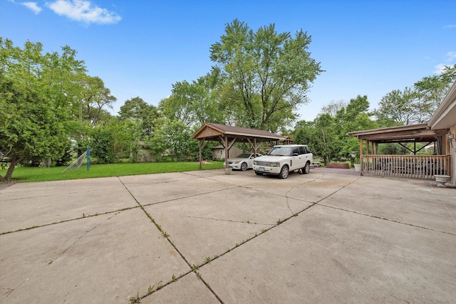 910 Sarah Ln, Aurora, IL 60502 - view of patio with concrete driveway, a detached carport, and view of scattered trees