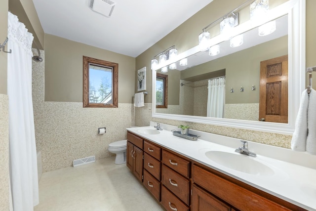 bathroom with a sink, toilet, and visible vents