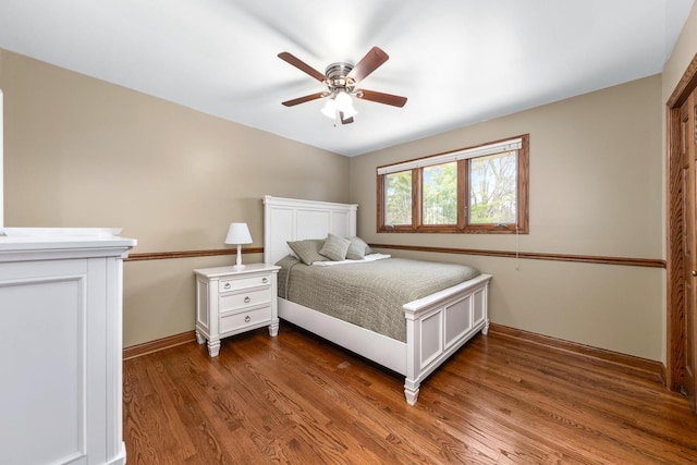 bedroom with a ceiling fan, baseboards, and wood finished floors
