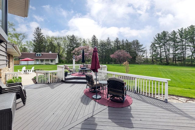 wooden terrace with a lawn and outdoor dining space