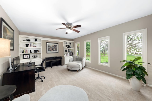 office area featuring light colored carpet, a ceiling fan, and a healthy amount of sunlight