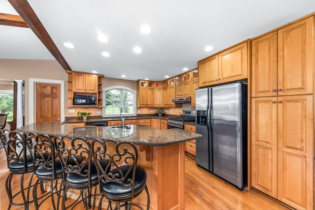 kitchen featuring open shelves, light wood-style flooring, recessed lighting, a center island with sink, and black appliances