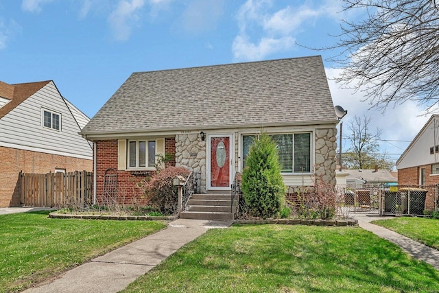 17531 Burnham Ave, Lansing, IL 60438 - new england style home featuring stone siding, a shingled roof, fence, and a front yard